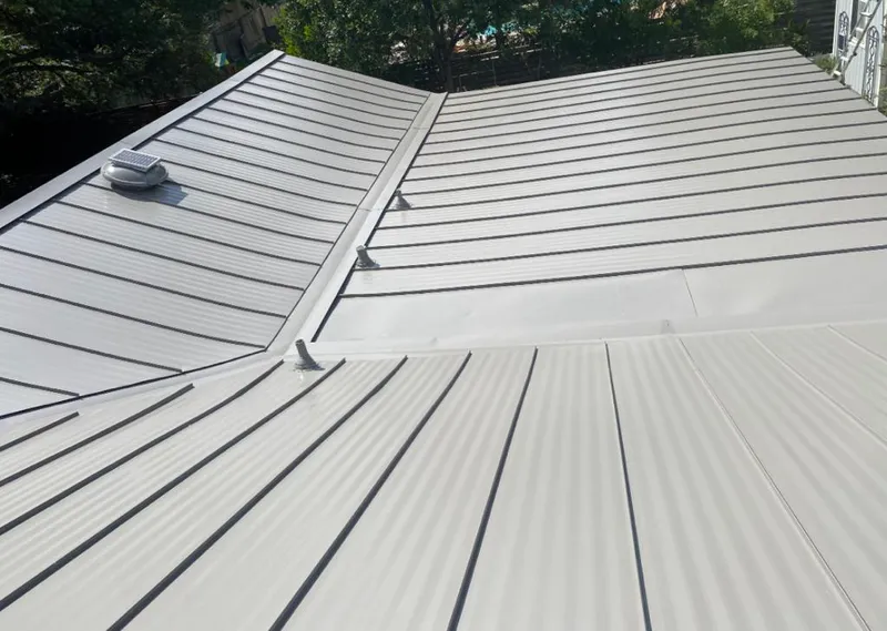 Solar attic fan installed on a metal roof for Roof Ventilation in Altus